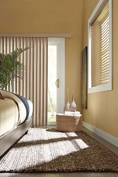 Beige vertical blind on a patio door and a slat blind in a bedroom