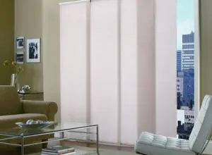 Pale pink sliding panels with a city view and a glass coffee table