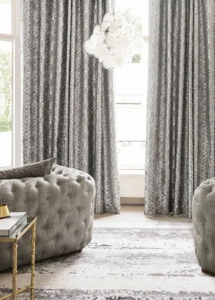 Rideaux gris à motif damassé et fauteuil capitonné, fenêtre claire